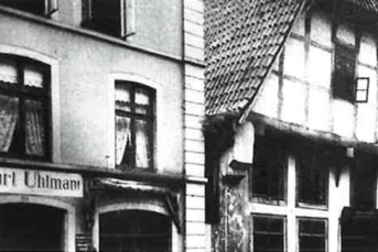 Das Bild zeigt zwei unterschiedliche Architekturstile: ein modernes und ein traditionelles Fachwerkhaus in Schwarz-Weiß.