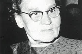 Mit einem ernsten Blick und leicht zusammengezogenen Augenbrauen wirkt die Frau nachdenklich und aufmerksam.